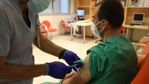 Un trabajador sanitario inyecta una dosis de la de Pfizer-BioNTech contra la Covid-19 a un sanitario del Hospital Infanta Sof&iacute;a de San Sebasti&aacute;n de los Reyes, Madrid (Espa&ntilde;a), a 9 de febrero de 2021.