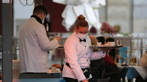 Dos camareros trabajan en la terraza de un bar en el centro de Madrid (Espa&ntilde;a)