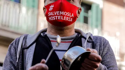 Un hombre con una mascarilla en la que se lee: `Salvemos la hosteler&iacute;a&acute; durante la cacerolada promovida por La Coordinadora Empresarial del Ocio y la Hosteler&iacute;a contra el cierre de la hosteler&iacute;a en la Comunidad Valenciana, en Valencia (Espa&ntilde;a), a 21 de en
