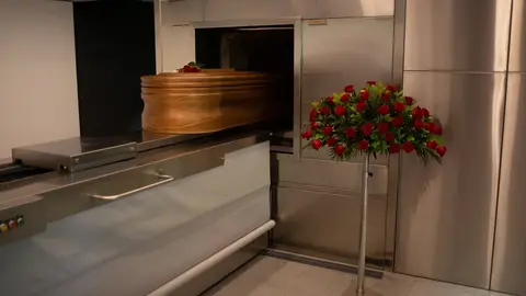 Un ata&uacute;d, ya desinfectado, de una v&iacute;ctima con Covid-19, es introducido en el horno crematorio. Archivo