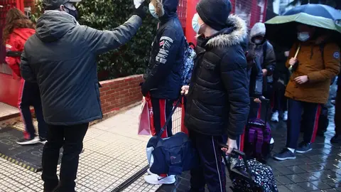 Archivo - Un trabajador toma la temperatura a un alumno antes de entrar al colegio 