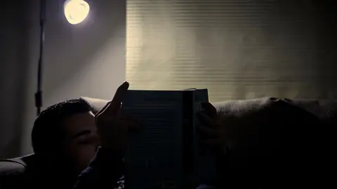 Archivo - Un chico lee un libro bajo la luz de una l&aacute;mpara en Madrid (Espa&ntilde;a), a 12 de enero de 2021. El precio mayorista de la electricidad subir&aacute; este martes un 2,18% con respecto al marcado este lunes, manteni&eacute;ndose as&iacute; por encima de los 80 euros por m