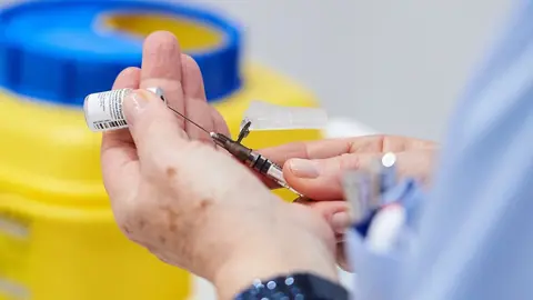 Una trabajadora sanitaria de Cantabria sostiene una vacuna contra el Covid. Archivo