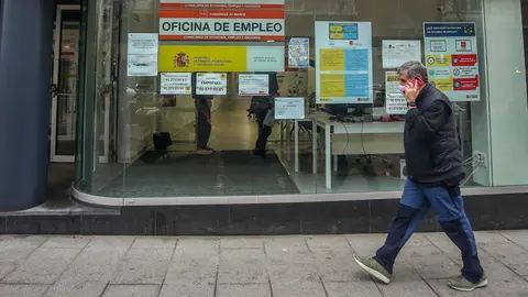 Archivo - Una persona pasa por delante de una Oficina de Empleo