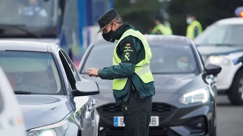 Archivo - Un agente de la Guardia Civil pide la documentaci&oacute;n a un veh&iacute;culo durante un control efectuado en Laredo, Cantabria.