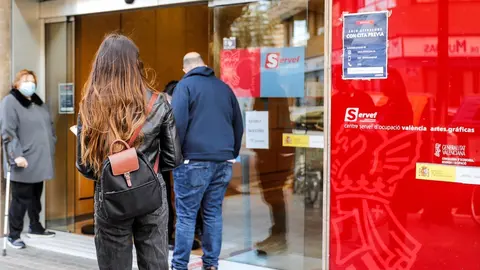 Archivo - Varias personas con cita previa esperan para entrar en una oficina del SEPE