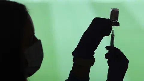 Un profesional sanitaria sostiene una jeringuilla y un vial con la vacuna del Covid-19, en un dispositivo instalado en el Estadio Wanda Metropolitano, en Madrid (Espa&ntilde;a), a 30 de marzo de 2021.