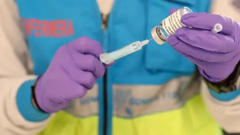 Un profesional sanitaria sostiene una jeringuilla y un vial con la vacuna del Covid-19, en un dispositivo instalado en el Estadio Wanda Metropolitano, en Madrid (Espa&ntilde;a), a 30 de marzo de 2021.