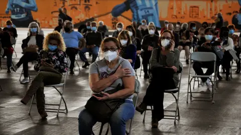 Fila de pacientes que esperan sentados tras recibir la primera dosis de la vacuna AstraZeneca en el recinto de Expourense, a 6 de abril de 2021, en Ourense, Galicia (Espa&ntilde;a).