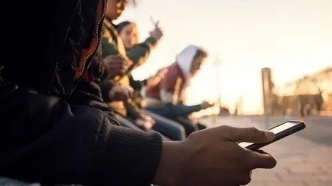 Archivo - J&oacute;venes con tel&eacute;fonos m&oacute;viles.- Archivo