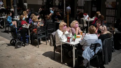 Varias personas en la terraza de un bar, el d&iacute;a en que se ampl&iacute;an a seis los comensales por mesa, a 12 de abril de 2021, en Valencia, Comunidad Valenciana (Espa&ntilde;a).