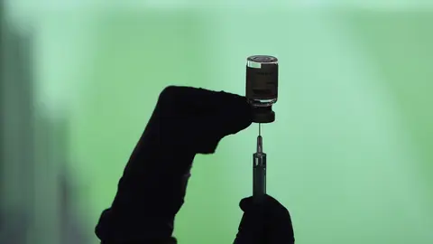 Un profesional sanitaria sostiene una jeringuilla y un vial con la vacuna del Covid-19, en un dispositivo instalado en el Estadio Wanda Metropolitano, en Madrid (Espa&ntilde;a), a 30 de marzo de 2021.