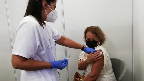 Una mujer se vacuna contra la covid-19 en el centro de vacunaci&oacute;n masiva de Infecar