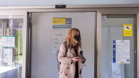 Una mujer entra por la puerta de una oficina del SEPE