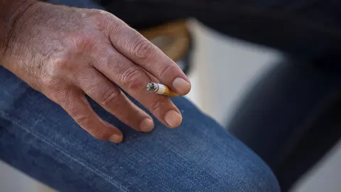 Archivo - Una persona fuma en la terraza de un bar durante el primer d&iacute;a de la prohibici&oacute;n de realizarlo en la v&iacute;a p&uacute;blica en Andaluc&iacute;a si no existe una distancia de dos metros de separaci&oacute;n con otras personas para evitar contagios de Covid-19. En M&aacute;laga,