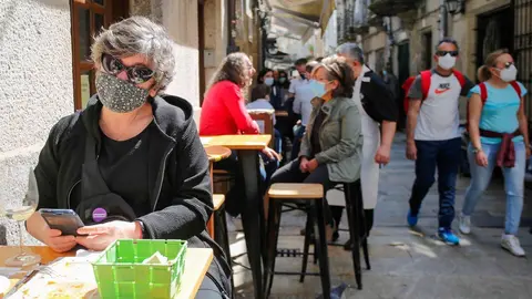 Archivo - Varias personas en una calle de terrazas de Baiona, en Vigo, Pontevedra, Galicia (Espa&ntilde;a), a 28 de marzo de 2021. El subcomit&eacute; cl&iacute;nico mantiene el nivel alto de restricciones en el concello de Baiona, lo que conlleva que la hosteler&iacute;a solo puede