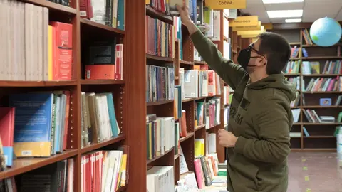 Archivo - Un trabajador coloca libros en una librer&iacute;a. Archivo