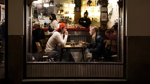 Dos j&oacute;venes en el interior de un bar en el barrio de las Letras, zona t&iacute;pica de tapas y copas de la capital, a 14 de mayo de 2021, en Madrid (Espa&ntilde;a). Madrid ha reforzado el dispositivo de la Polic&iacute;a Municipal para este San Isidro, apoyo que ha arrancado 