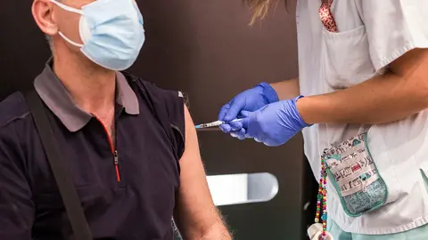 Una sanitaria administra la primera dosis de la vacuna de Pfizer a un hombre, en el Hospital Universitario de Getafe, a 17 de mayo, en Getafe, Madrid (Espa&ntilde;a). La Comunidad de Madrid ha comenzado hoy a vacunar a personas entre 50 y 55 a&ntilde;os en los hospital