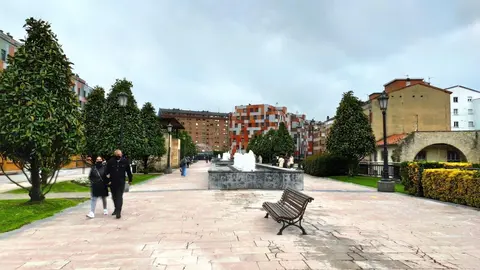 Personas paseando por La Losa de Oviedo en un d&iacute;a de primavera, con mascarillas.