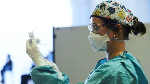 Archivo - Una profesional sanitaria sostiene un vial con la vacuna de AstraZeneca, durante el inicio de la campa&ntilde;a de vacunaci&oacute;n masiva frente al Covid-19, en el Palacio de Exposiciones y Congresos de Santander, 