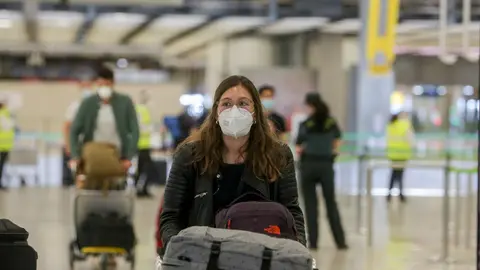 Archivo - Una joven protegida con mascarilla camina por el Aeropuerto de Madrid-Barajas Adolfo Su&aacute;rez el d&iacute;a en el que se estrena el triple control sanitario de seguridad contra el Covid-19, en Madrid (Espa&ntilde;a) a 21 de junio de 2020.