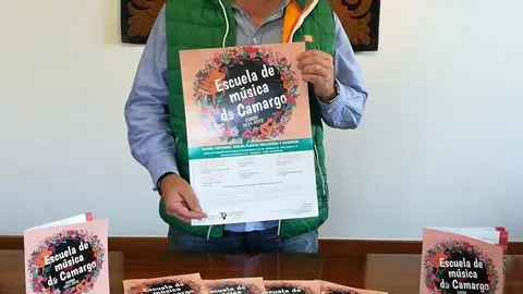 El concejal de Cultura de Camargo, Jos&eacute; Salm&oacute;n, con el cartel anunciador del nuevo curso en la Escuela de M&uacute;sica