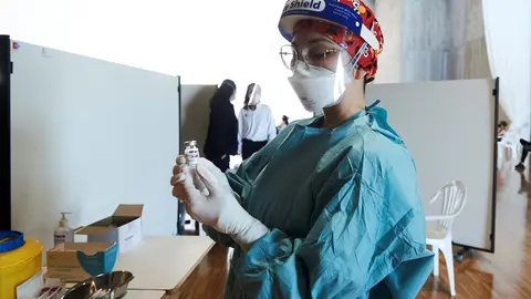 Archivo - Una profesional sanitaria sostiene un vial con la vacuna de AstraZeneca en el Palacio de Exposiciones y Congresos de Santander.