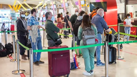 Varias personas hacen fila con maletas en la terminal T4 del Aeropuerto Adolfo Su&aacute;rez Madrid-Barajas, a 21 de mayo de 2021.