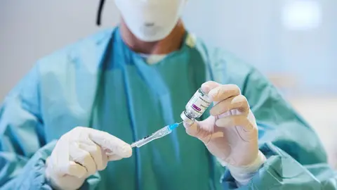 Archivo - Una profesional sanitaria sostiene un vial con la vacuna de AstraZeneca