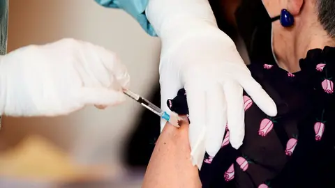 Archivo - Una profesional sanitaria sostiene un vial con la vacuna del Covid