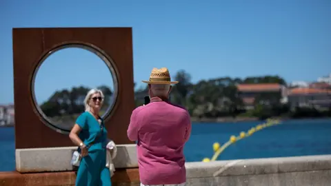 Un hombre echa una foto a una mujer en el paseo mar&iacute;timo de la playa de Sanxenxo, a 4 de junio de 2021, en Sanxenxo, Pontevedra, Galicia, (Espa&ntilde;a). El aumento de las temperaturas y la progresiva mejora de la situaci&oacute;n epidemiol&oacute;gica ha colaborado en que l