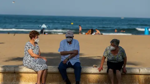 Archivo - Tres personas mayores descansan en el paseo mar&iacute;timo de la playa de la Malvarrosa.