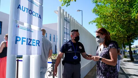 Un polic&iacute;a controla la entrada de varias personas a las afueras del Hospital p&uacute;blico de emergencias Enfermera Isabel Zendal, a 28 de junio de 2021, en Madrid, (Espa&ntilde;a).