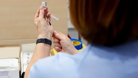 Archivo - Una trabajadora sanitaria sostiene una jeringuilla