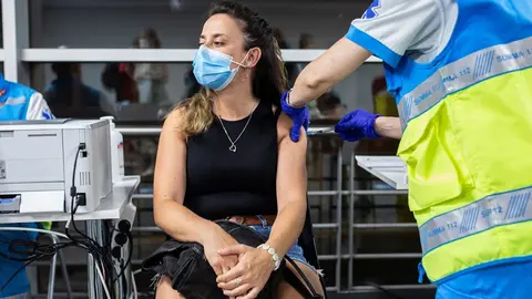 Un sanitario administra una dosis de la vacuna de Pfizer a una mujer en el Wizink Center durante la primera noche en la que el recinto est&aacute; abierto a la vacunaci&oacute;n, a 1 de julio de 2021, en Madrid (Espa&ntilde;a).