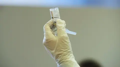 Archivo - Una profesional sanitaria sostiene un vial con la vacuna de AstraZeneca