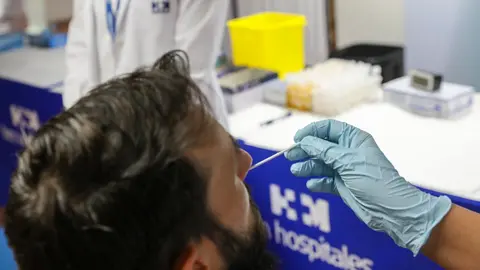 Un sanitario realiza un test de ant&iacute;genos a un hombre