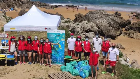 Voluntarios de Cruz Roja retiran 104 kilos de basuraleza de la playa de Valdearenas, en Liencres.