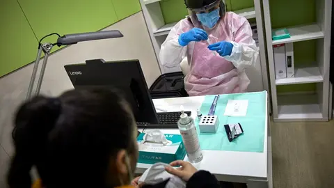 Archivo - Una farmac&eacute;utica prepara un test de ant&iacute;genos para realiz&aacute;rselo a una mujer en la Farmacia Las Gemelas en Madrid (Espa&ntilde;a), a 11 de febrero de 2021.