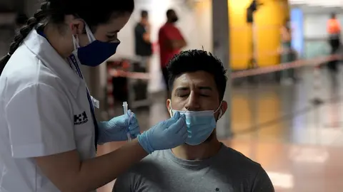 Una sanitaria realiza un test de ant&iacute;genos a un hombre, en un dispositivo de realizaci&oacute;n de test de ant&iacute;genos en el intercambiador de Plaza de Castilla, a 2 de julio de 2021, en Madrid (Espa&ntilde;a).