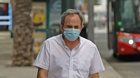 Un anciano pasea con mascarilla junto a un term&oacute;metro que marca 42&ordm; durante un d&iacute;a de alerta roja por altas temperaturas, a 12 de julio de 2021, en la ciudad de Murcia, Murcia (Espa&ntilde;a). Las provincias de Alicante, Valencia y Murcia tienen este lunes aviso