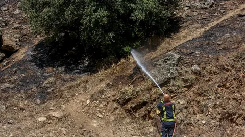 Un bombero trabaja en la extinci&oacute;n de uno de los focos del incendio del pantano de San Juan, a 1 de agosto de 2021, en San Mart&iacute;n de Valdeiglesias, Madrid (Espa&ntilde;a). 