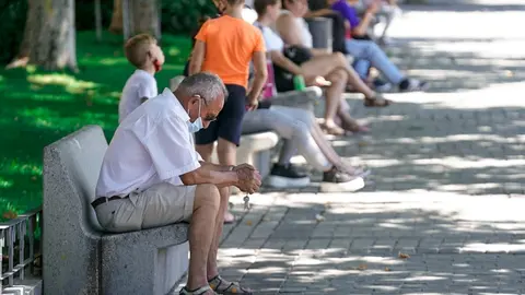 Un anciano con mascarilla sentado en un banco, a 27 de julio de 2021, en Madrid, (Espa&ntilde;a).