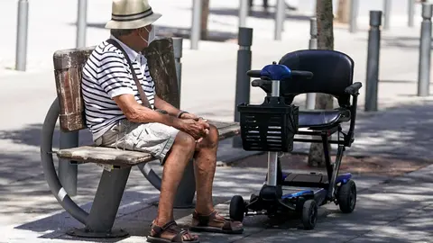 Un anciano con mascarilla sentado en un banco, a 27 de julio de 2021, en Madrid, (Espa&ntilde;a).