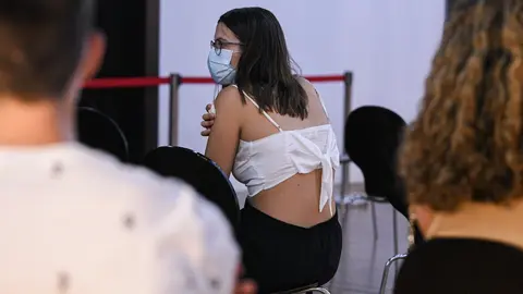 Una adolescente espera en una sala, despu&eacute;s de recibir la primera dosis de la vacuna Pfizer en el punto de vacunaci&oacute;n de X&aacute;tiva, situado en el Hogar de los Jubilados, a 10 de agosto de 2021, en X&aacute;tiva, Valencia, Comunidad Valenciana (Espa&ntilde;a).
