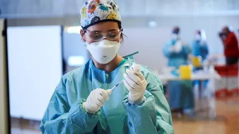 Archivo - Una profesional sanitaria sostiene un vial con la vacuna de AstraZeneca.- Archivo