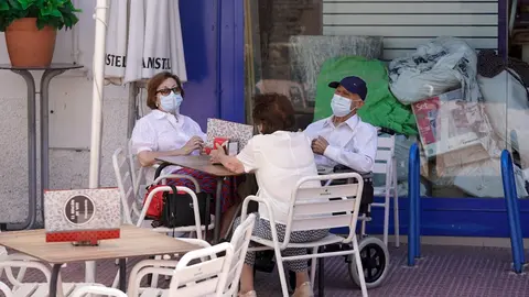 Ancianos con mascarilla conversan sentados en la terraza de un bar, a 27 de julio de 2021, en Madrid, (Espa&ntilde;a).