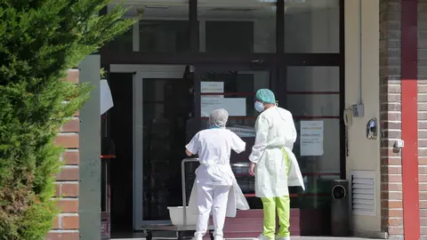 Dos trabajadores conversan en la puerta de una residencia.- Archivo