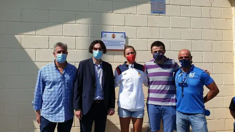 Virginia D&iacute;az, con autoridades municipales, posando junto a la placa colocada en las instalaciones deportivas de la Sociedad de Remo de Astillero, en conmemoraci&oacute;n de su actuaci&oacute;n en los Juegos Ol&iacute;mpicos de Tokyo 2020